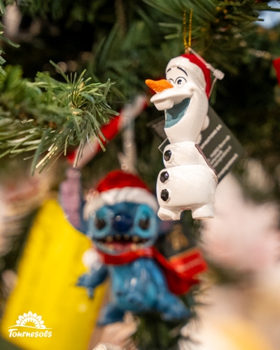 Ornements Disney Olaf et Stitch sur un sapin de Noël.